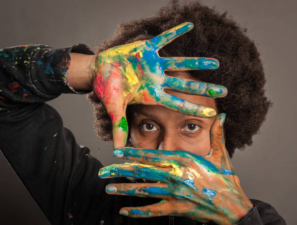 black woman with her hands painted on a gray background