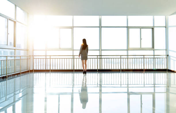 istock Businesswoman standing and looking through the window 1140139784
