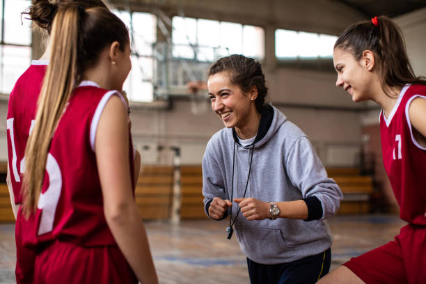 istock Beautiful female coach cheering girls before match 1140140868