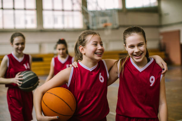 Friendship on basketball court Cute teenage girls, smiling and hugging after basketball match, happy after winning the game competition stock pictures, royalty-free photos & images