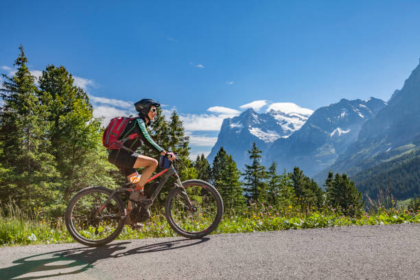 senior donna mountain biking a grindelwald - monch foto e immagini stock