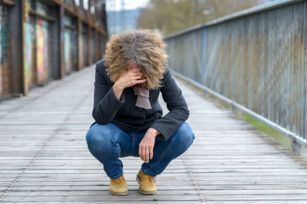 istock Dejected woman squatting on a bridge 1140142831