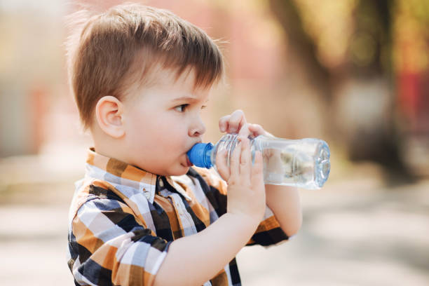 istock handsome boy drinks clear water from a bottle on a sunny day outside 1140143046