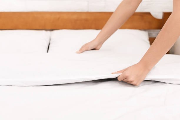 istock Young woman making bed and organizing room 1140144176