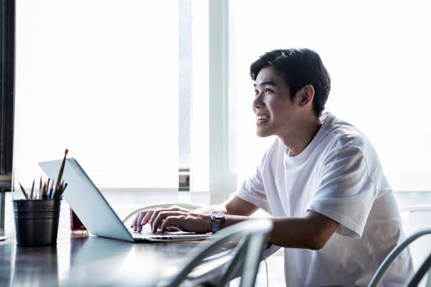 istock Young Asian Man Happily Working In The Office On His Laptop Computer 1140144305