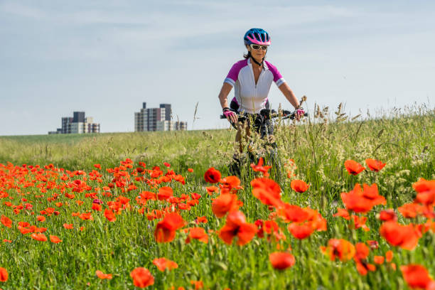 donna mountain bike in primavera - plant poppy oriental poppy green foto e immagini stock