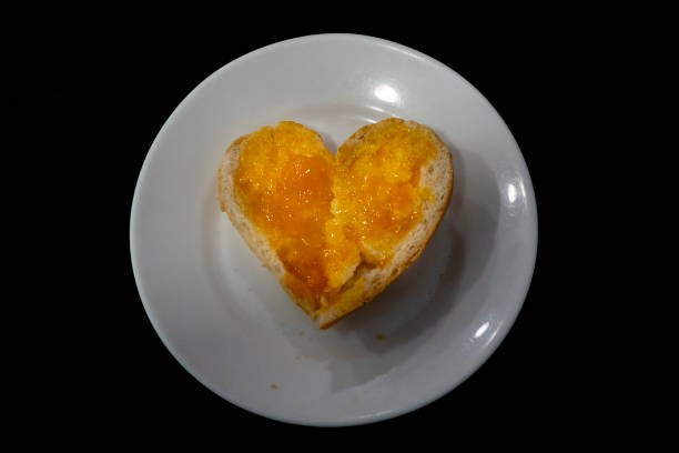 hearth shaped bread with jam marmalade isolated on black - wheat pasta flour italy imagens e fotografias de stock