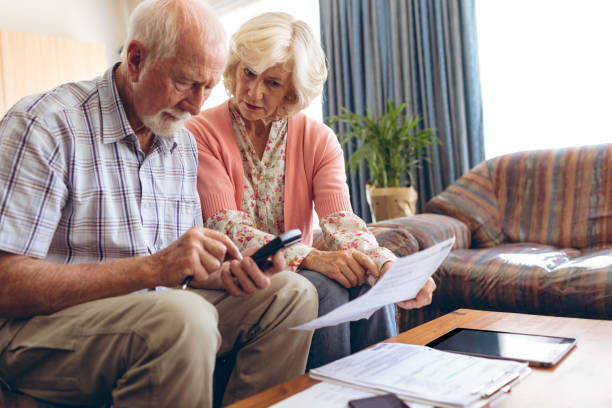istock Senior couple calculating bill while sitting at retirement home 1140149048