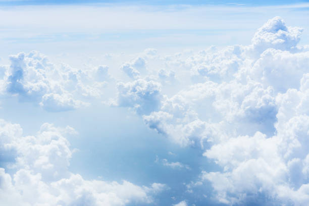 Sky above clouds with nice dramatic light. View from airplane window stock photo