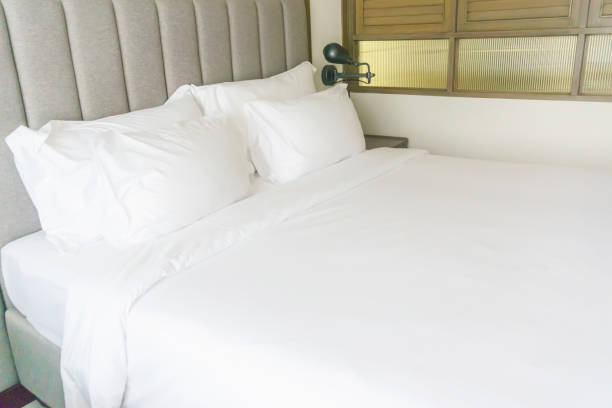 istock Tidy bed with bedside lamps 1140149405