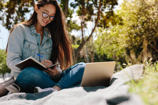 istock Happy girl studying in a park 1140150258