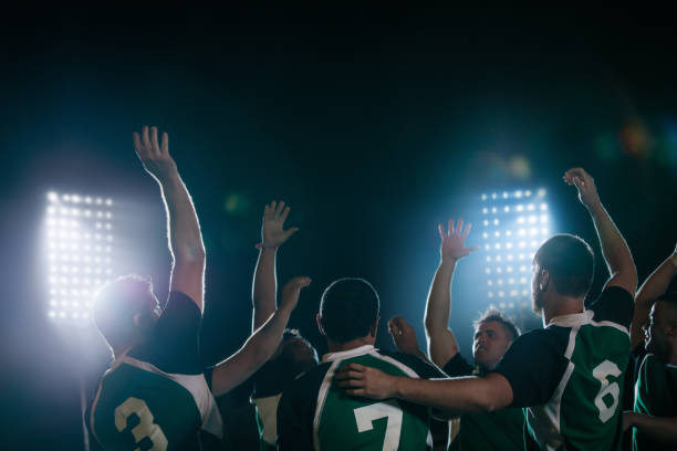 Rugby league champions celebrating victory Group of rugby team player cheering the win at sports arena under lights. Rugby players celebrating victory. rugby team stock pictures, royalty-free photos & images