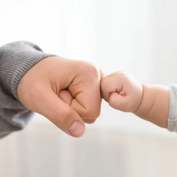 Photo of Close up of father holding baby hand