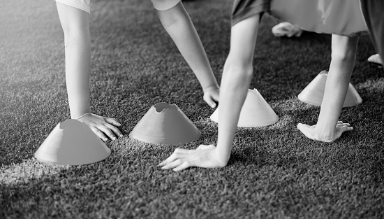 black and white image of hand sensitivity test competition for holding cones, Kid soccer are training in the football academy