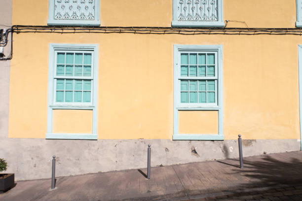Typical Canarian house fronts / facades with plastered or tiled walls, barred windows and shutters found alongside the coast of this sunny island.