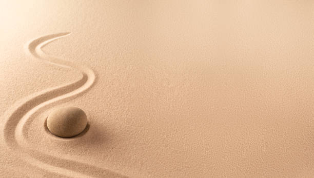 Spa wellness background of a zen meditation garden with sand and round stone Spa wellness background of a zen meditation garden with sand and round stone. A nice curved line on sandy texture. Lots of copy space. spa belgium stock pictures, royalty-free photos & images