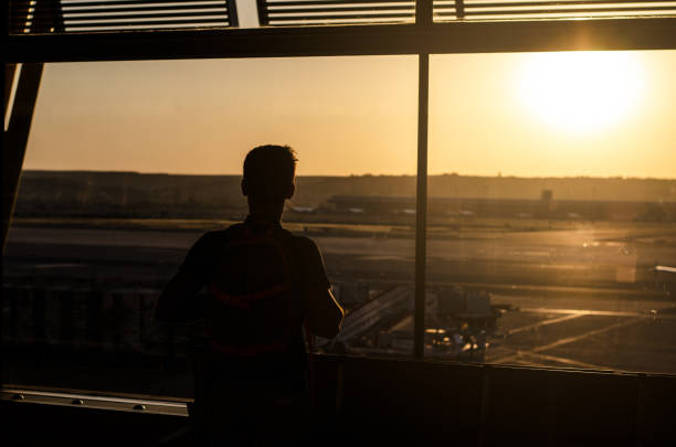 istock Thoughtful young man looking by the window at a airport terminal 1140167457