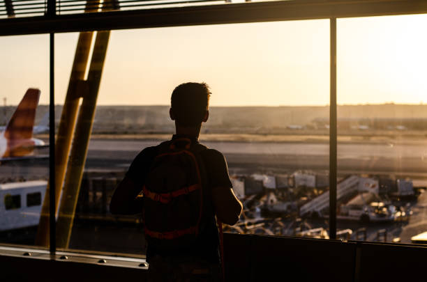 istock Thoughtful young man looking by the window at a airport terminal 1140167479
