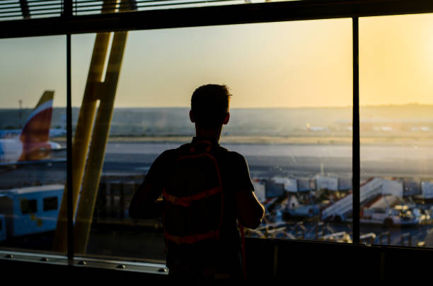 istock Thoughtful young man looking by the window at a airport terminal 1140167515