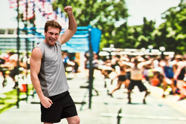 istock Handsome man is standing at an outside sporting event and cheering 1140168169