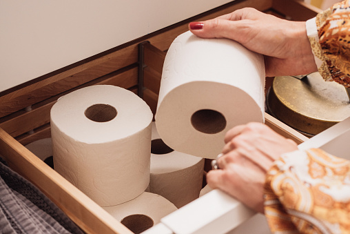 Toilet paper storage in bathroom drawer
Photo of female hand grabbing a new roll