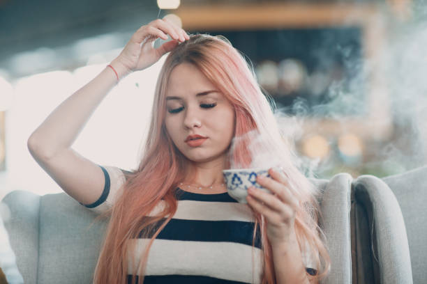 istock Young pretty girl drinks hot smoking tea in cafe. 1140170169
