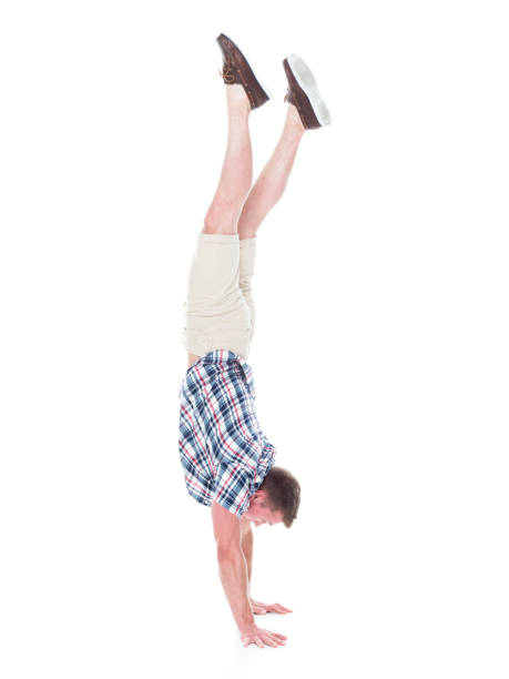istock Handsome man in shirt and shorts is doing a handstand 1140170453