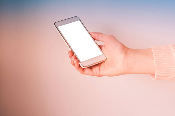 Woman's hand with mobile phone screen on pink and blue gradient abstract background. Empty screen for your text.