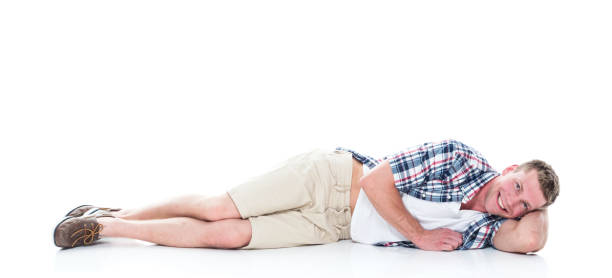 istock Handsome man in shirt and shorts is lying down and relaxing 1140171224