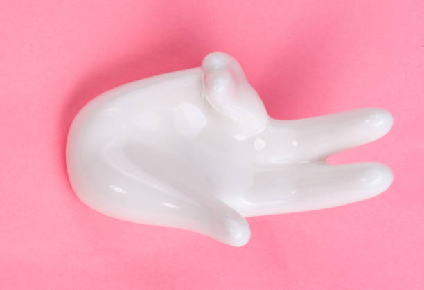 istock Ceramic stand with hand shape on pink background 1140173176