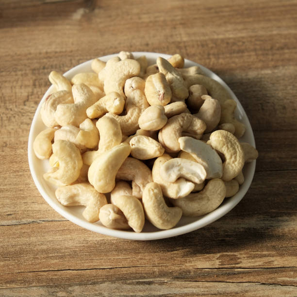 istock Cashew nuts on a wooden background in a plate. Beautiful nuts on the table 1140173871