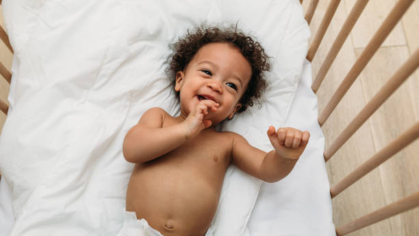 istock Laughing baby boy lying down on a bed 1140180043
