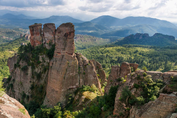 istock Belogradchik rocks during summer, with trees surrounding the stunning rock formations. 1140180780