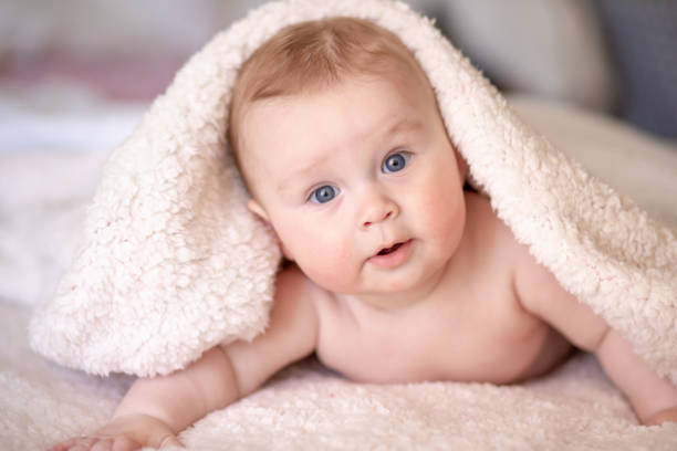 istock baby lying on a bed under towel 1140181553