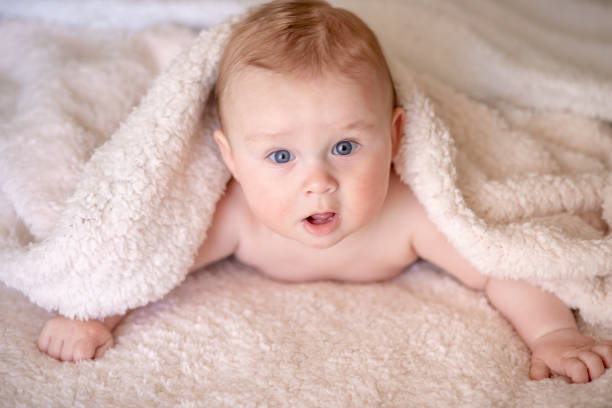 istock baby lying on a bed under towel 1140181555