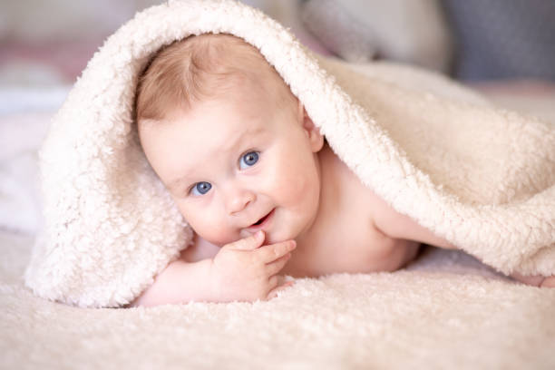 istock baby lying on a bed under towel 1140181577