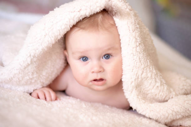 istock baby lying on a bed under towel 1140181584