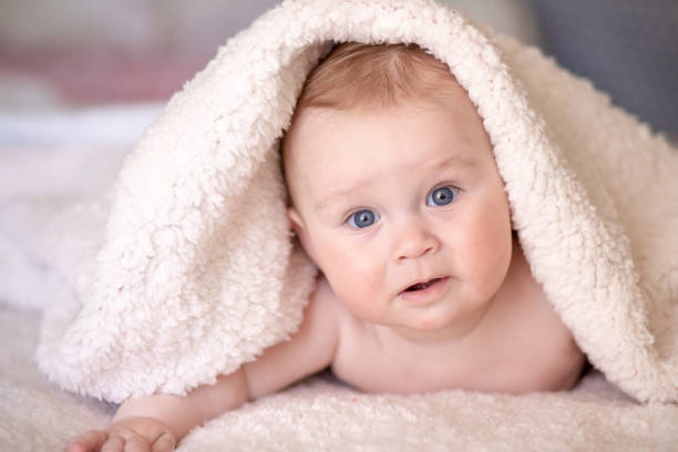 istock baby lying on a bed under towel 1140181591