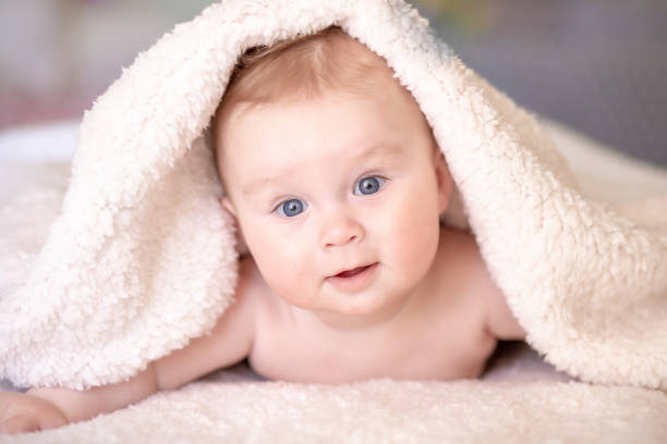 istock baby lying on a bed under towel 1140181611