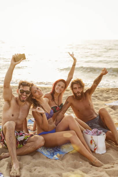 istock Friends at sea: relaxing on the beach at sunset 1140182147