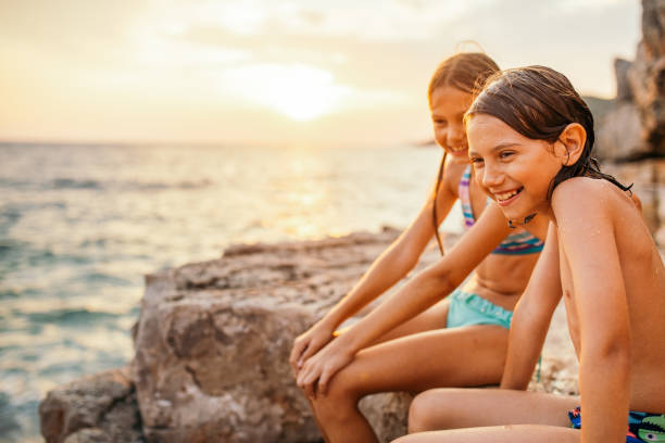 istock Boy and girl relaxing on beach at sunset 1140182286