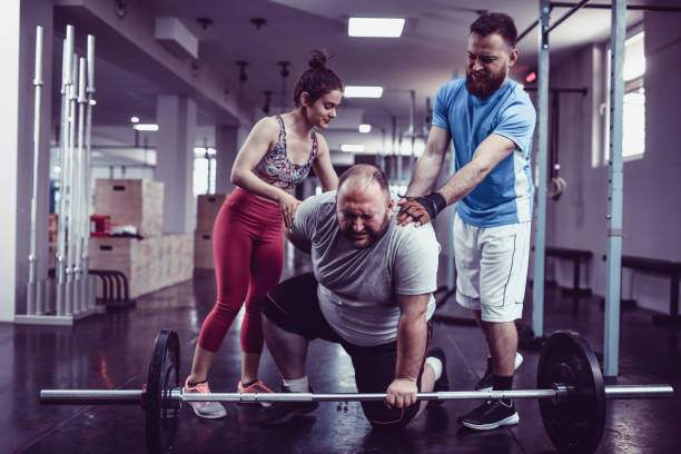 istock Fitness Instructors Helping Overweight Male 1140185524