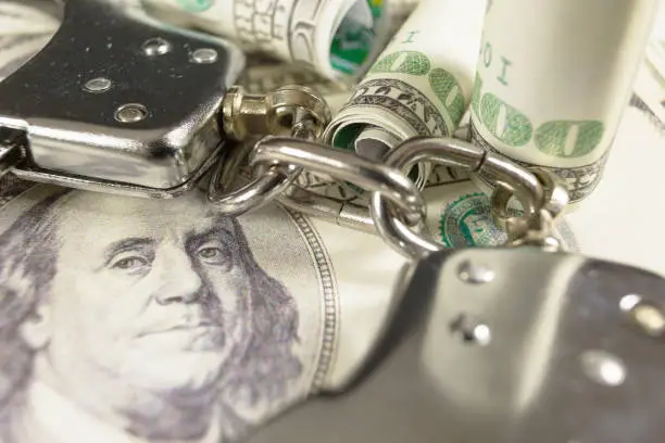 Photo of Handcuffs on a dollar bills