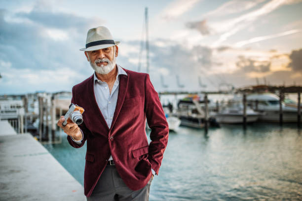 turista sênior do latino que viaja ao lado do mar e que usa a câmera - marina yacht florida sunset - fotografias e filmes do acervo