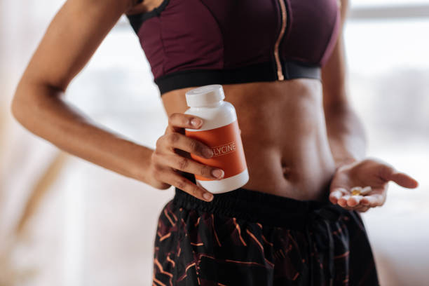 istock Fit woman with nice abs drinking supplements in the morning 1140193160