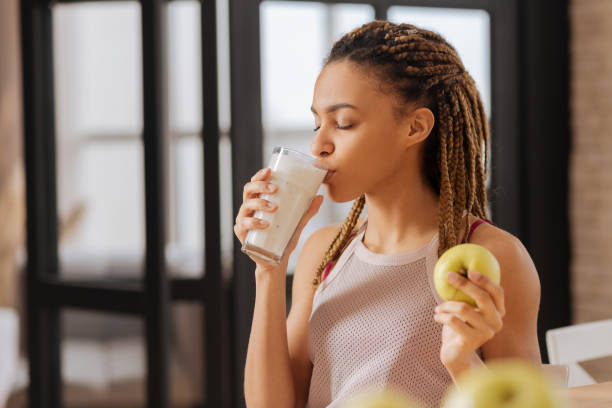 giovane donna con piccole trecce che bevono vetro di latte - thin curls foto e immagini stock