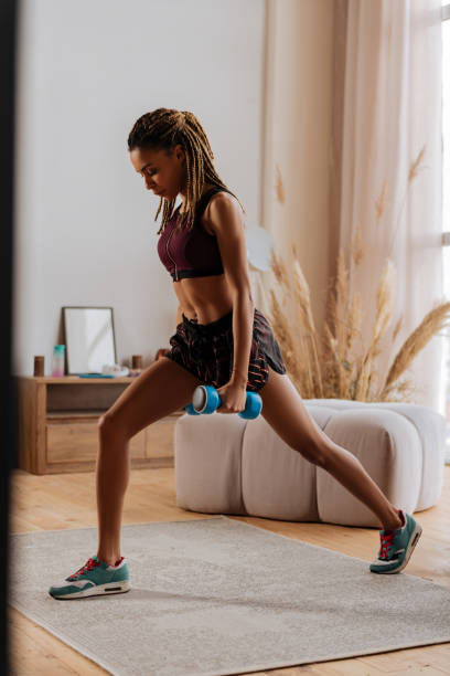 istock Sportswoman holding blue barbells while doing exercises 1140193305