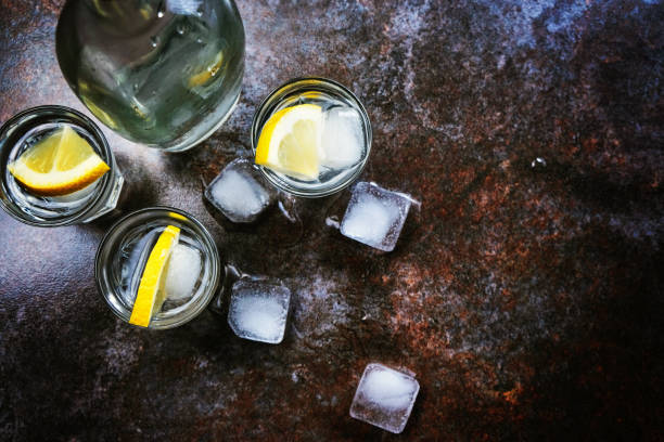 istock Cold vodka in shot glasses with lemon on stone background. Top view, copy space. 1140193400