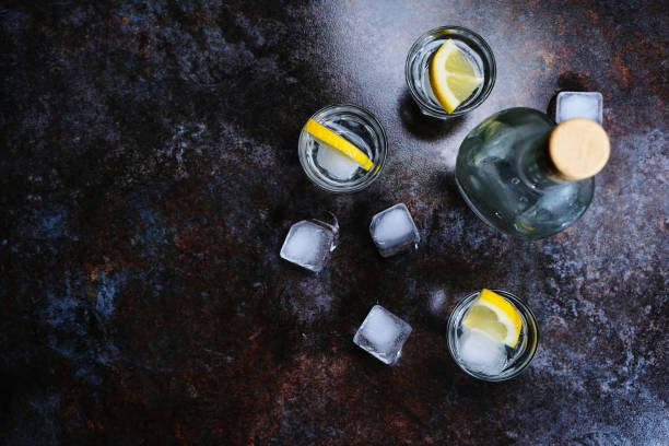 istock Cold vodka in shot glasses with lemon on stone background. Top view, copy space. 1140193401