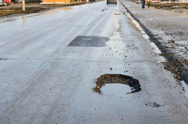 istock Big pothole on road after winter 1140193766